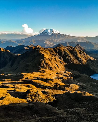 Child and adult jumping over a stream in the Ecuadorian Andes highlands